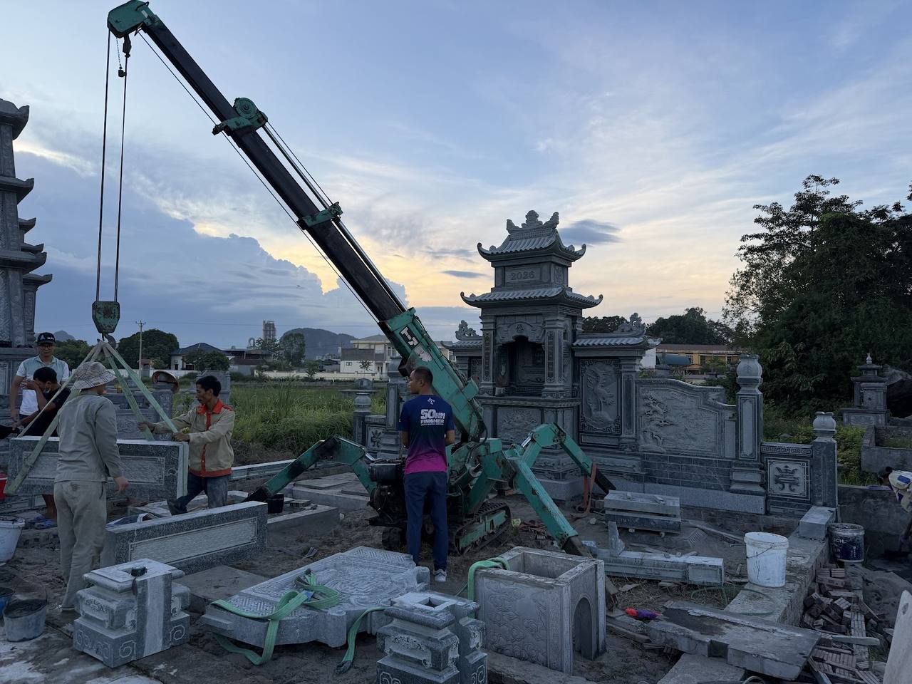 Lăng Mộ Đá Granite: Mẫu Đẹp và Bảng Giá 2026 4 Thi công lắp đặt lăng mộ đá granite bằng cẩu chuyên dụng tại công trình