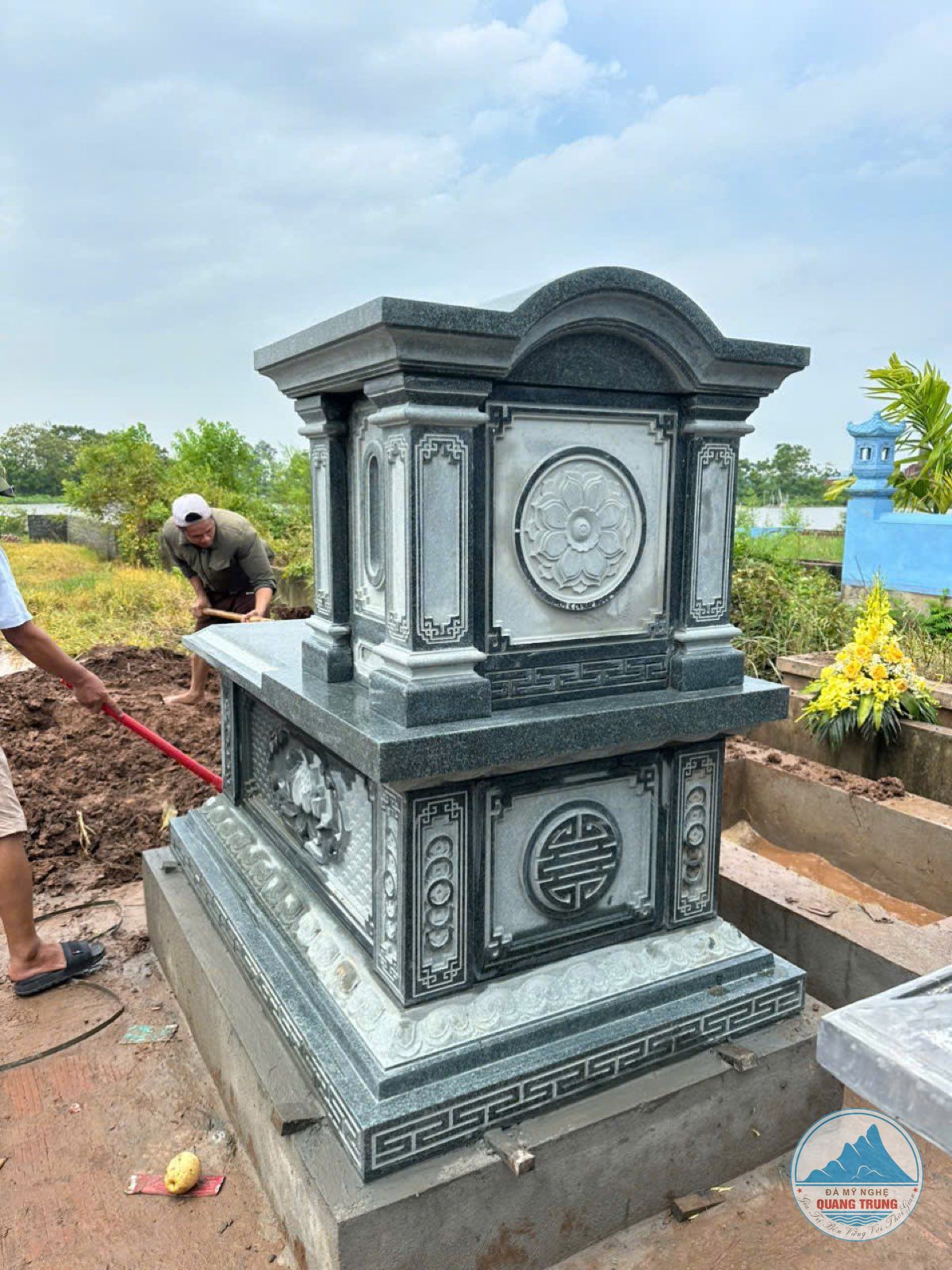 Thợ Quang Trung làm việc cạnh ngôi mộ đá trong lúc lắp đặt
