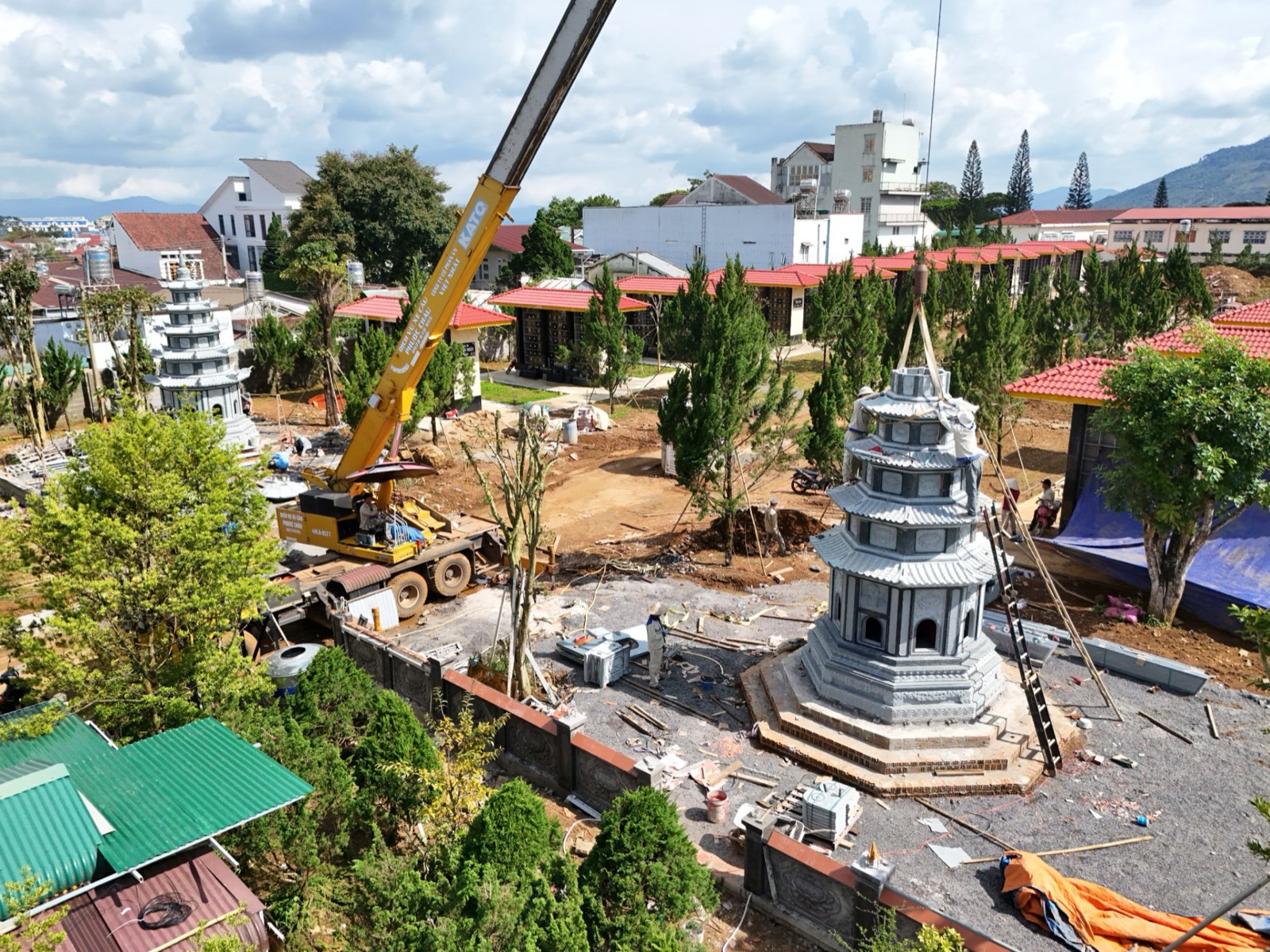 Hai tháp đá granite xanh dựng ở hai vị trí trong khuôn viên Chùa Phước Huệ, xe cẩu đứng giữa sân