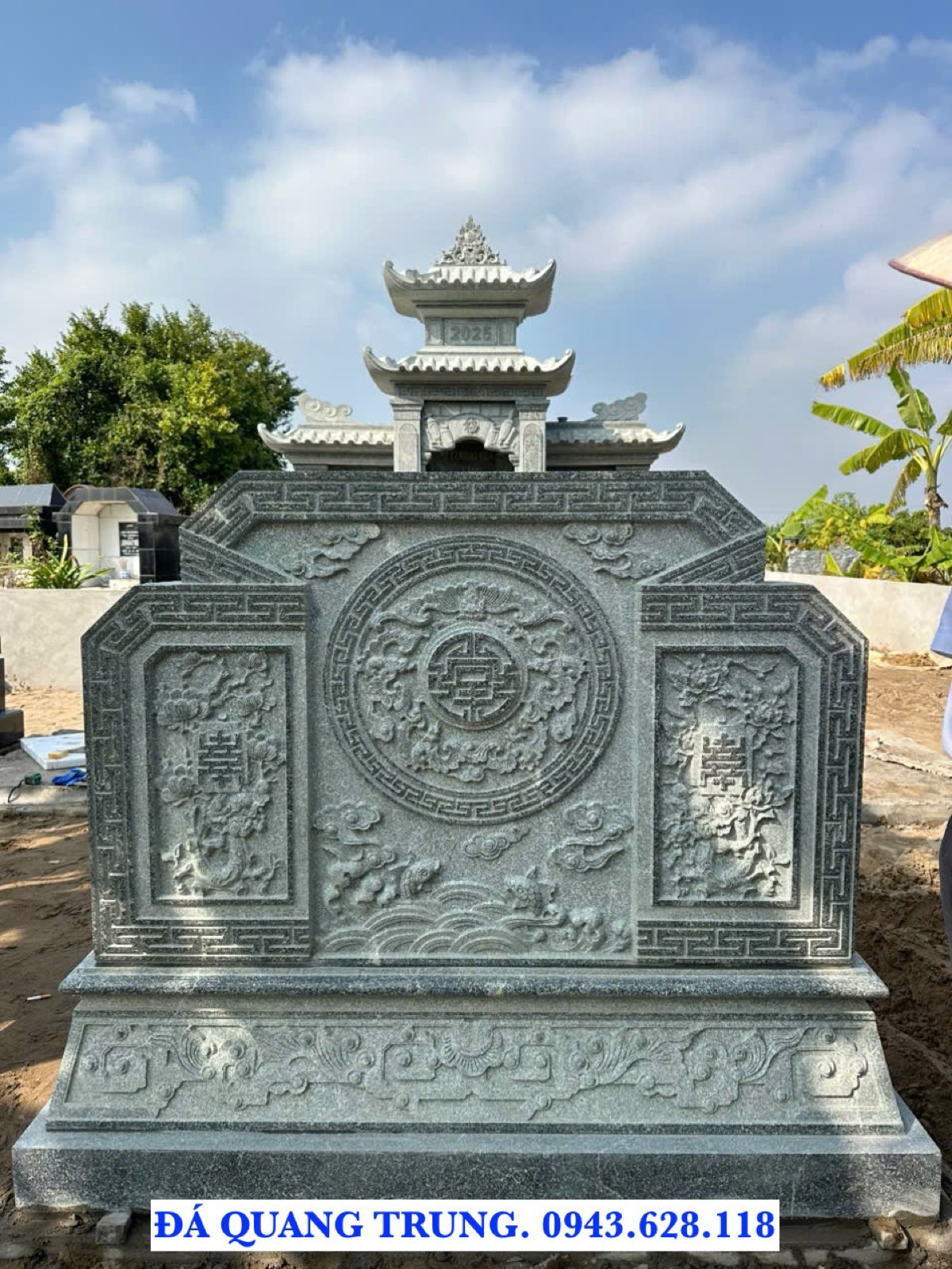 Cuốn thư đá vuông ba ô, ô giữa chạm chữ Thọ tròn, phía sau là mái lăng thờ đá